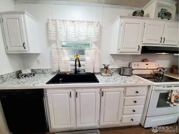 a kitchen with white cabinets and white appliances