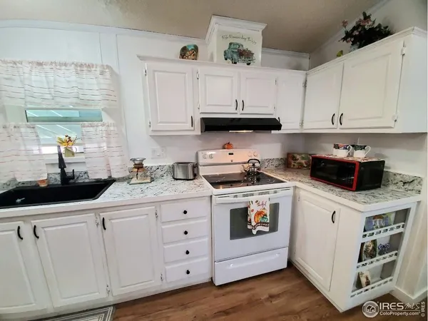 a kitchen with white cabinets and white appliances