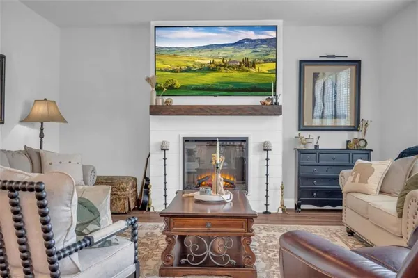 a kitchen with stainless steel appliances kitchen island a refrigerator a stove a dining table and chairs with wooden floor