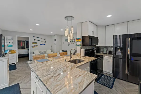 a kitchen with stainless steel appliances granite countertop a stove refrigerator and a sink