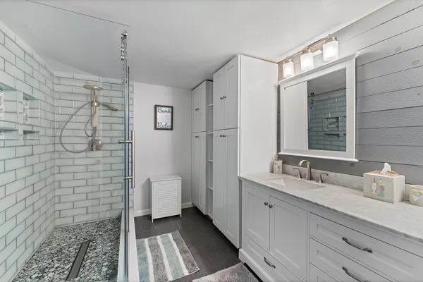 a bathroom with a sink a toilet and shower