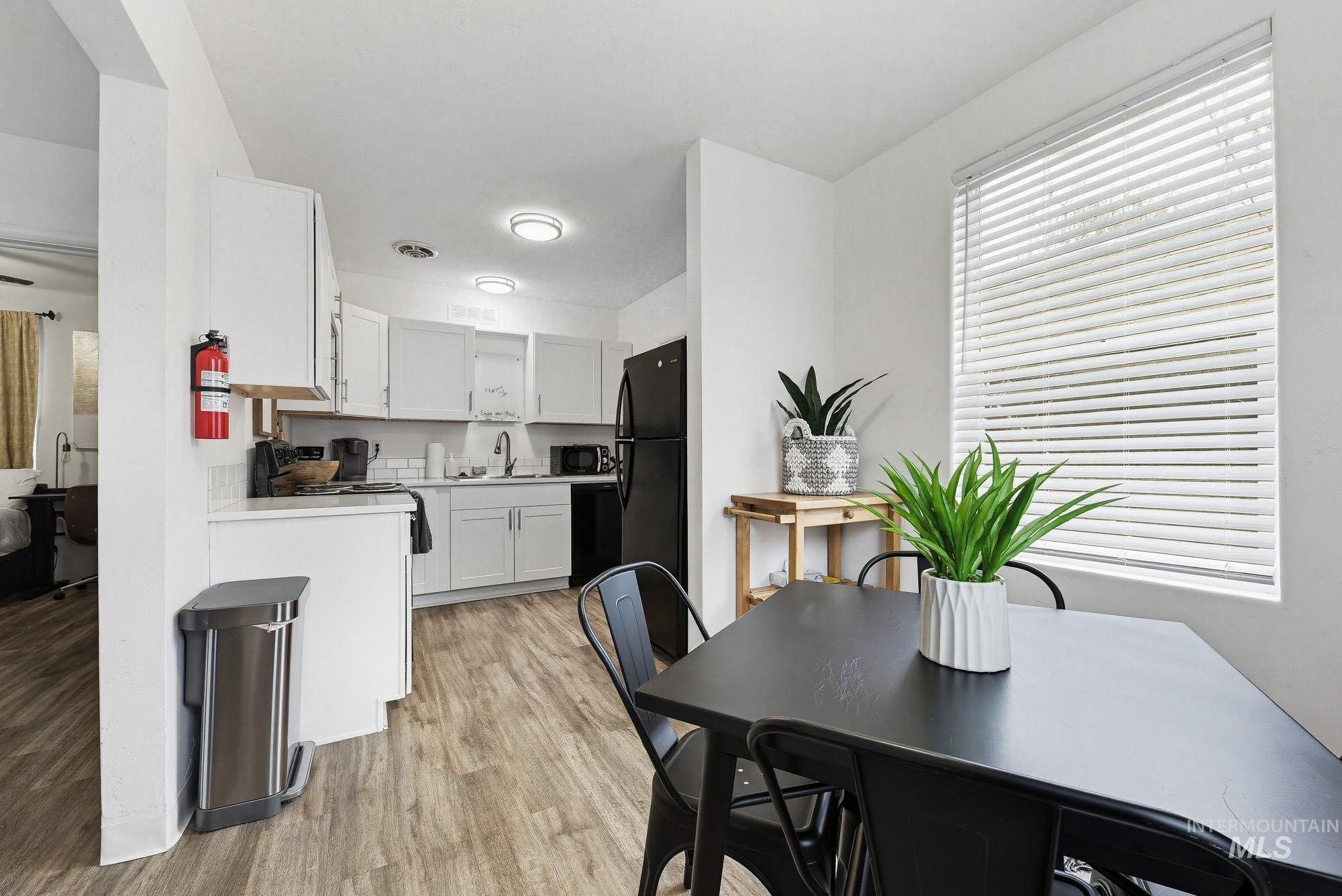 2104 North 18th Street Boise, ID 83702 - Photo 10 of 19 Kitchen with light countertops, white cabinetry, light wood-type flooring, and black appliances