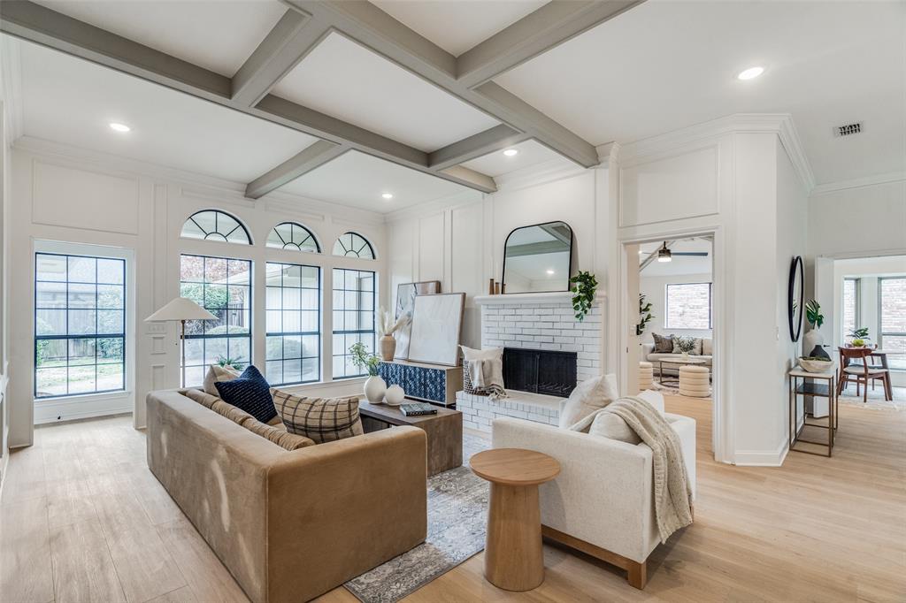 a living room with fireplace furniture and a large window