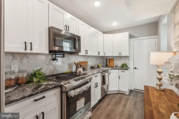 a kitchen with stainless steel appliances granite countertop a stove a sink and a refrigerator