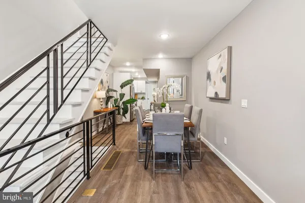 a dining room with furniture entryway and wooden floor