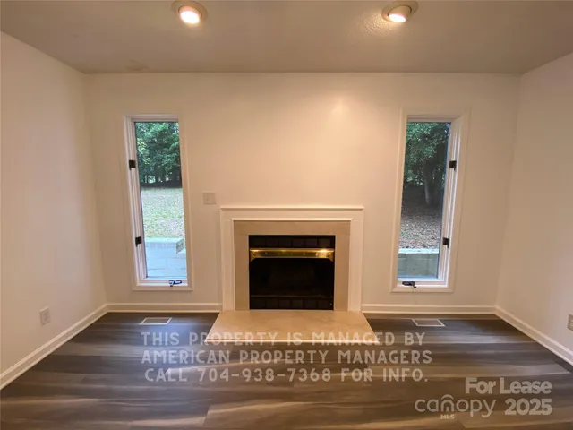 a living room with a fireplace and wooden floor