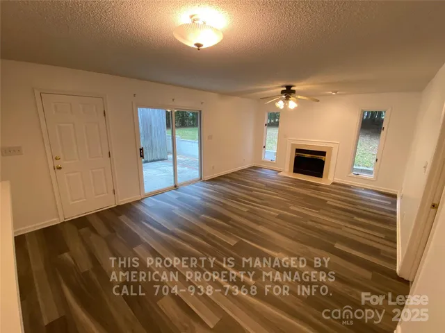 a view of an empty room with a fireplace and a window