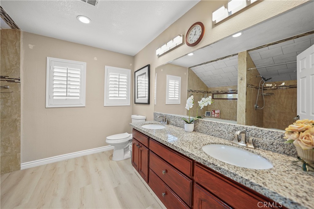 895 North Los Robles Avenue Pasadena, CA 91104 - Photo 22 of 58 a bathroom with a granite countertop sink a toilet and a mirror