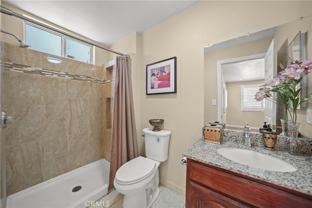 895 North Los Robles Avenue Pasadena, CA 91104 - Photo 50 of 58 a bathroom with a granite countertop sink a toilet and shower