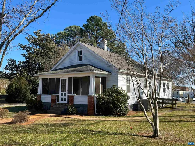 a view of a white house with large windows and a small yard