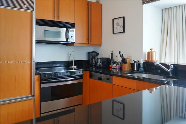 a kitchen with stainless steel appliances granite countertop a stove microwave and sink
