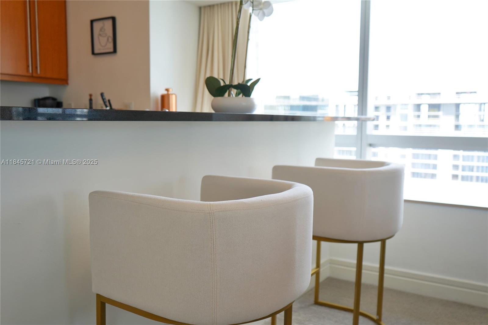 1435 Brickell Avenue, Unit 3412 Miami, FL 33131 - Photo 11 of 44 a kitchen with a table chairs stove and sink