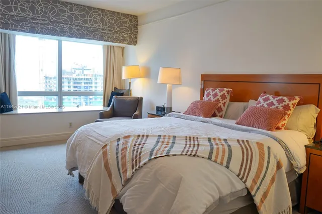 a bedroom with a bed and a large window