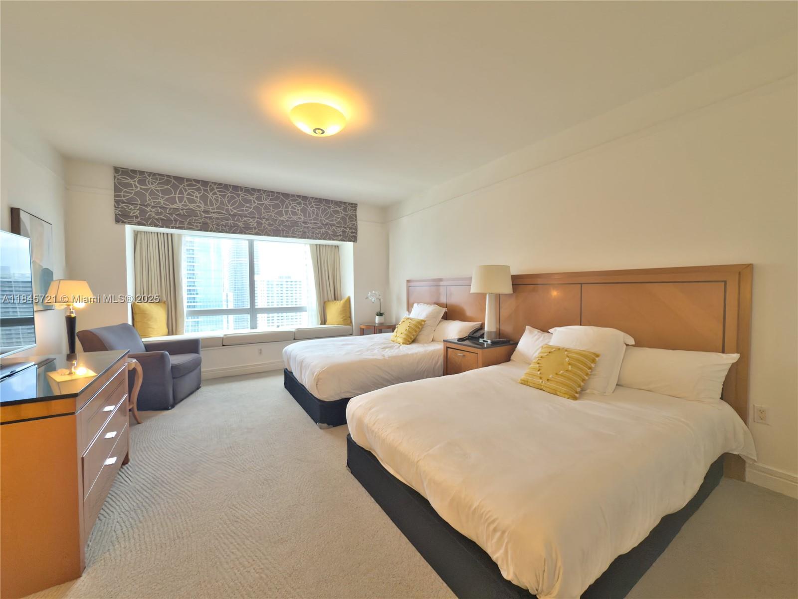 1435 Brickell Avenue, Unit 3412 Miami, FL 33131 - Photo 22 of 44 a bedroom with two beds and a large window