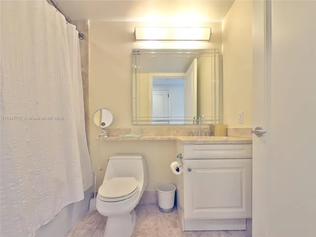 a bathroom with a toilet a sink a vanity and mirror