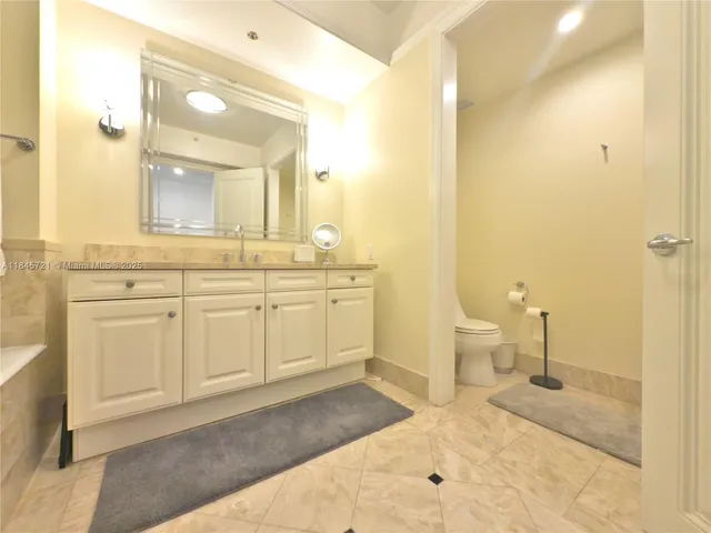 a spacious bathroom with a sink a toilet and a mirror