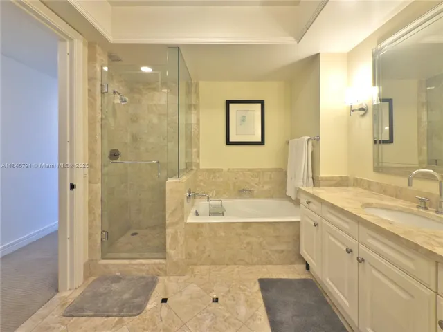 a spacious bathroom with a tub sink shower and a mirror