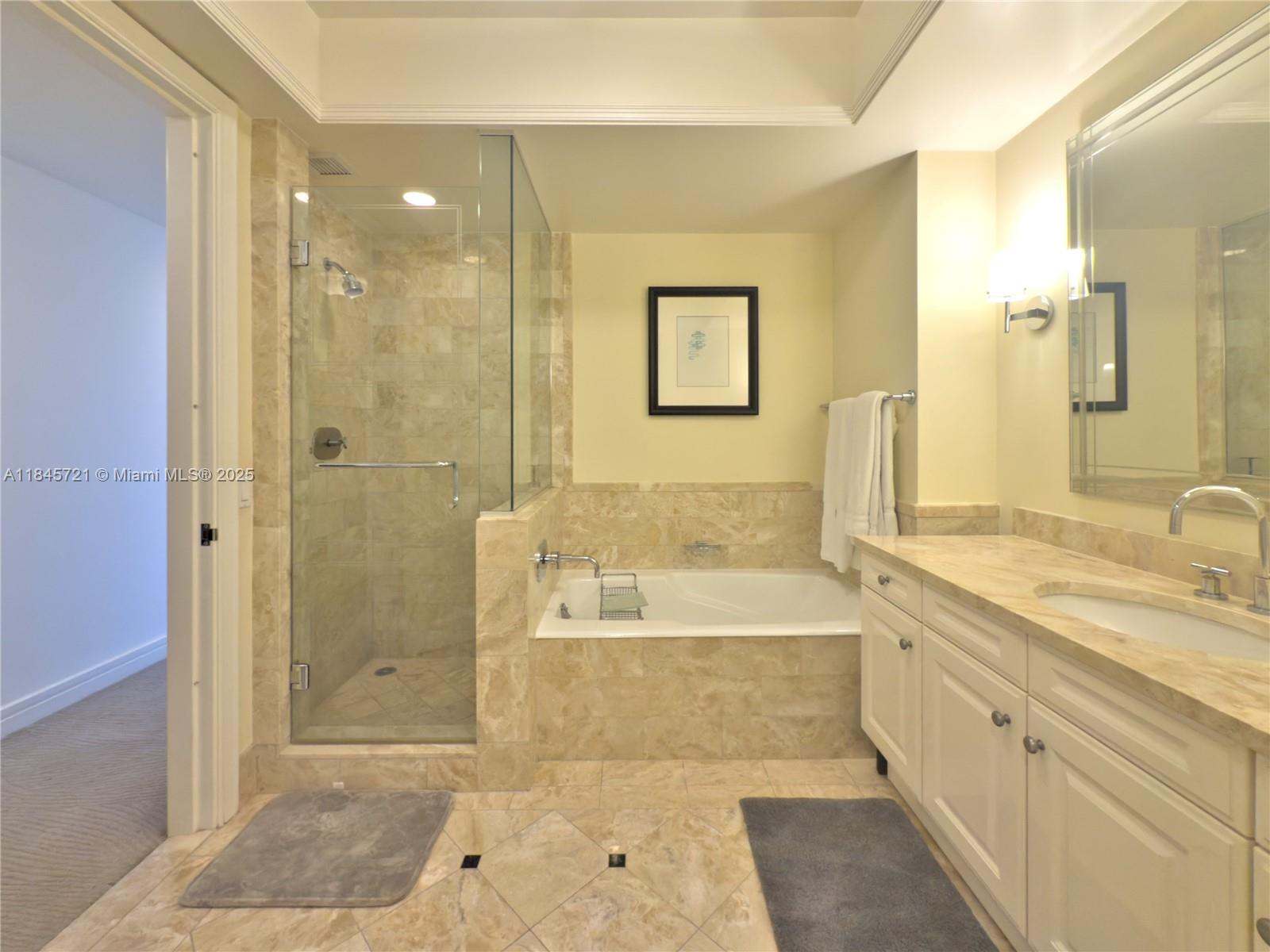 1435 Brickell Avenue, Unit 3412 Miami, FL 33131 - Photo 30 of 44 a spacious bathroom with a tub sink shower and a mirror