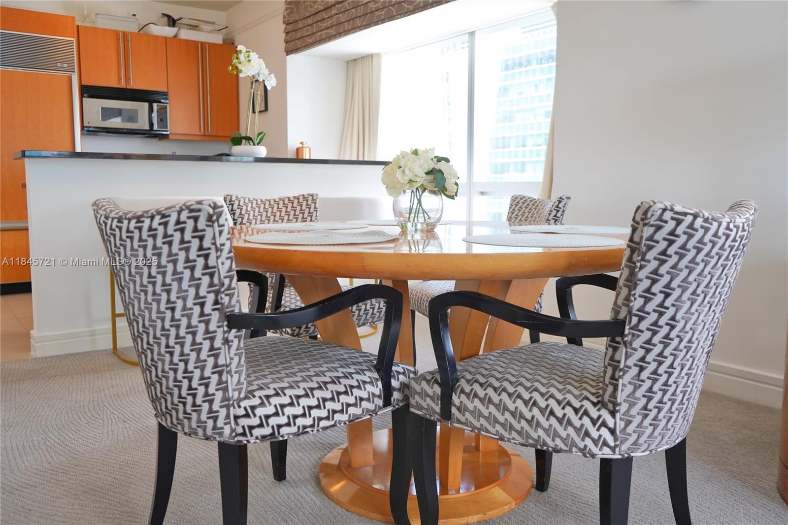 1435 Brickell Avenue, Unit 3412 Miami, FL 33131 - Photo 4 of 44 a dining room table with chairs and window