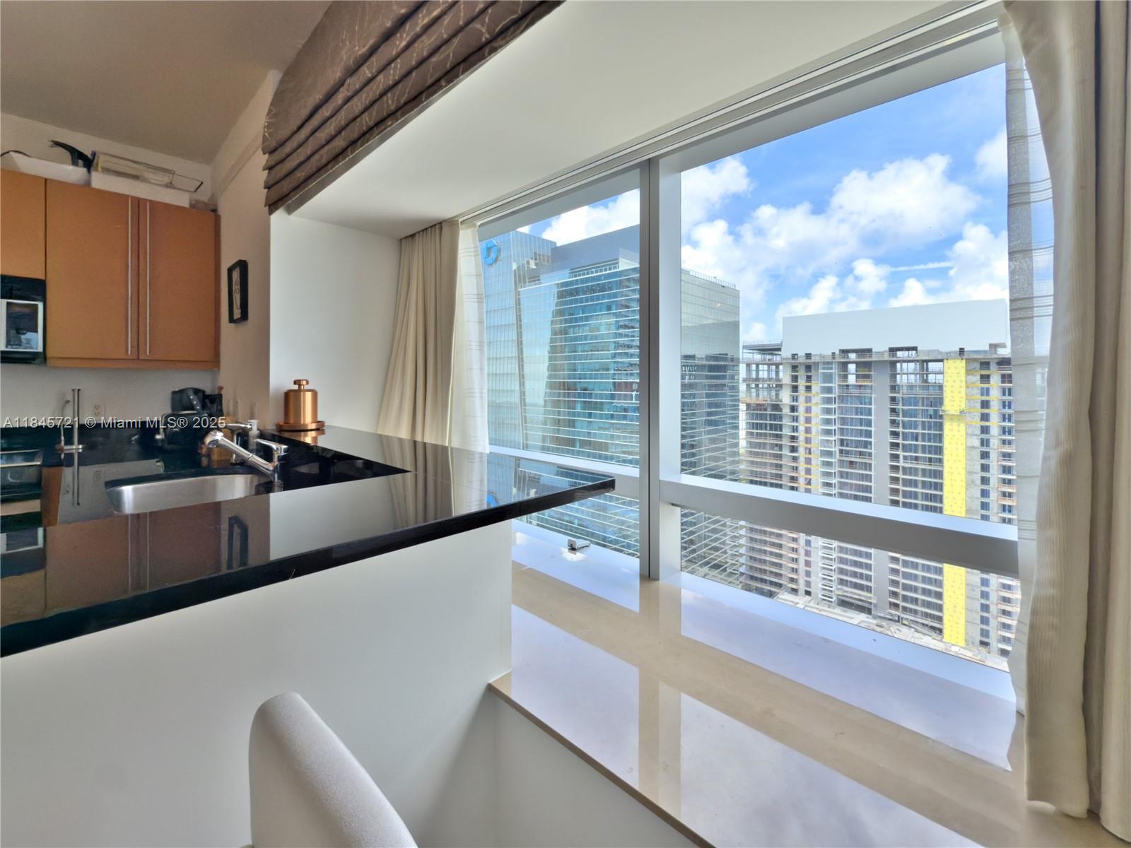 1435 Brickell Avenue, Unit 3412 Miami, FL 33131 - Photo 9 of 44 a kitchen with large windows and a sink