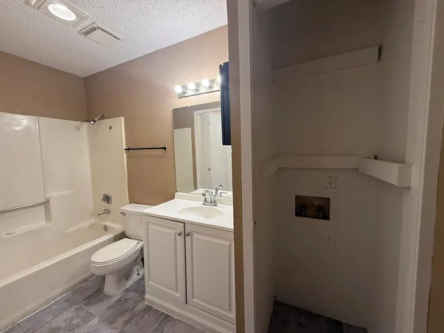 a bathroom with a granite countertop sink toilet a large mirror a bathtub and shower
