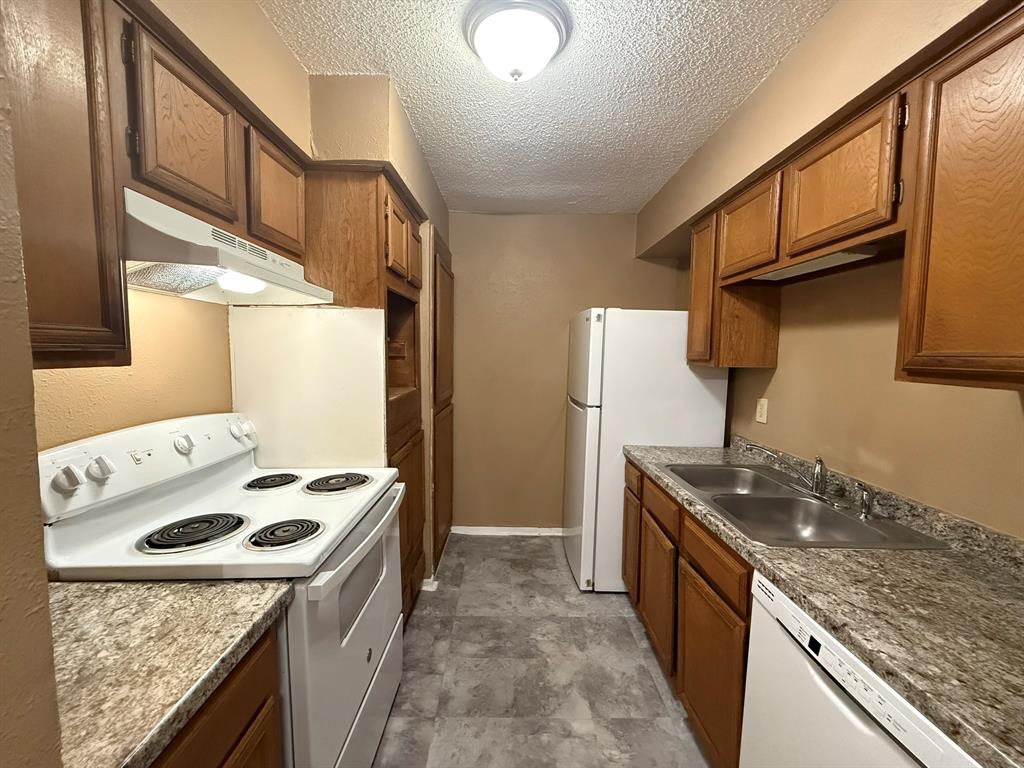 9696 Walnut Street, Unit 606 Dallas, TX 75243 - Photo 7 of 17 a kitchen that has a sink a stove and a refrigerator