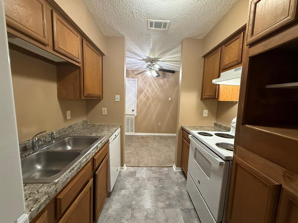 9696 Walnut Street, Unit 606 Dallas, TX 75243 - Photo 8 of 17 a kitchen with granite countertop a sink stove and refrigerator
