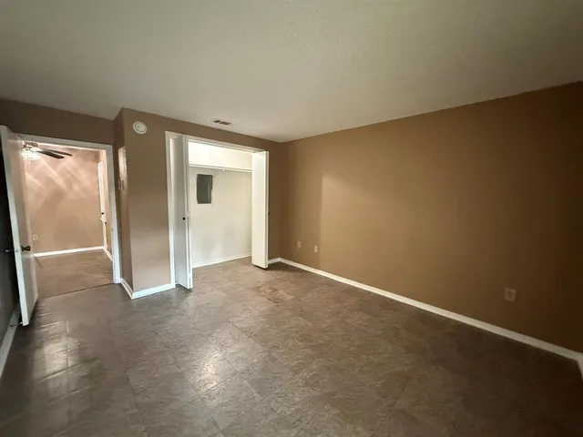 an empty room with windows and closet