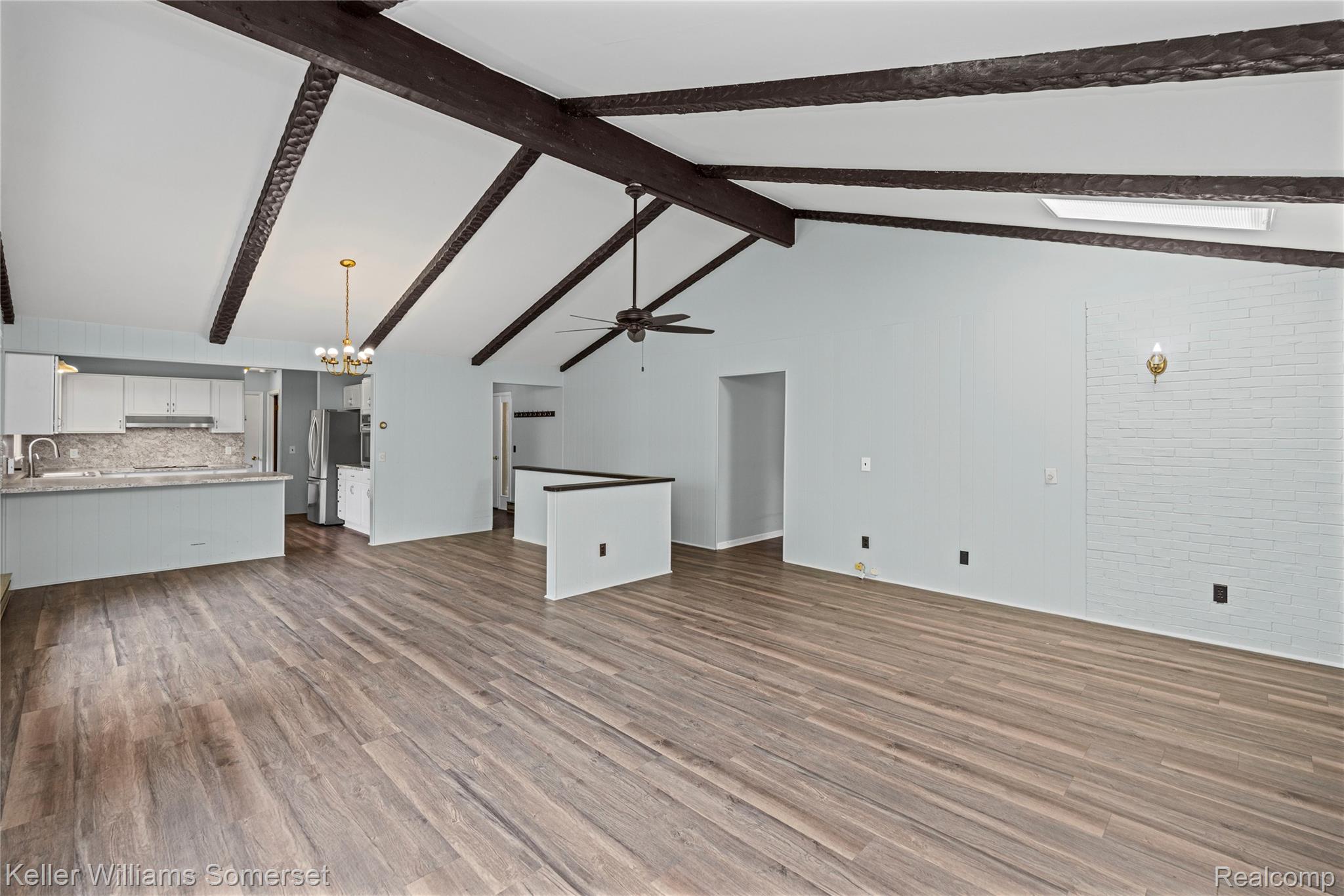 2344 Rochester Road Leonard, MI 48367 - Photo 12 of 66 Vaulted ceiling with exposed wood beams, wood-finish flooring, recessed lighting, and a skylight