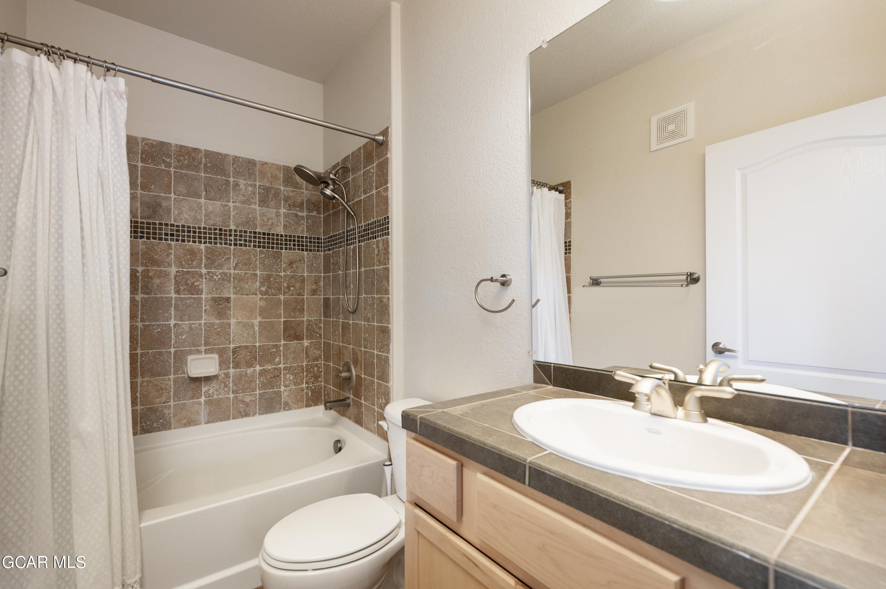 152 Village Road, Unit B306 Granby, CO 80446 - Photo 13 of 32 a bathroom with a granite countertop sink toilet a mirror and bathtub