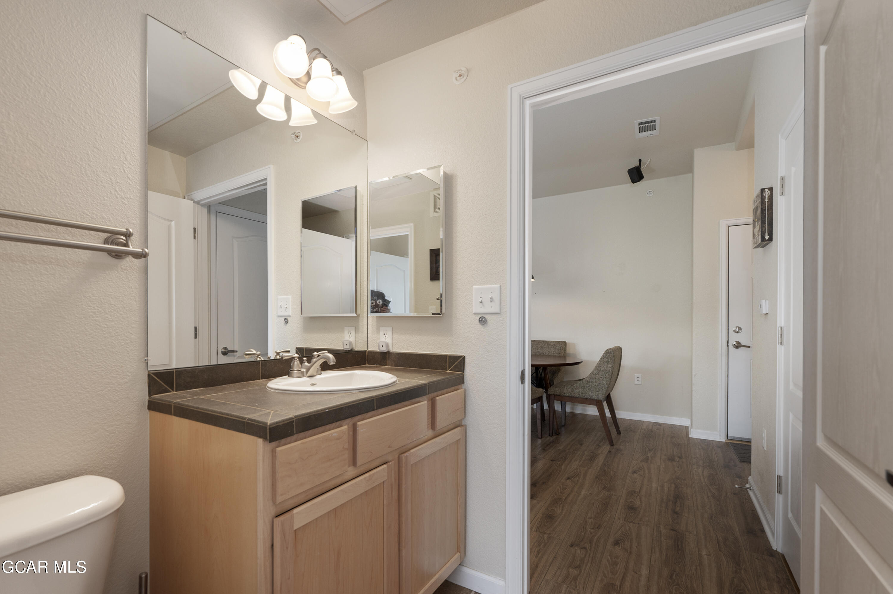 152 Village Road, Unit B306 Granby, CO 80446 - Photo 17 of 32 a bathroom with a granite countertop sink a toilet and a mirror