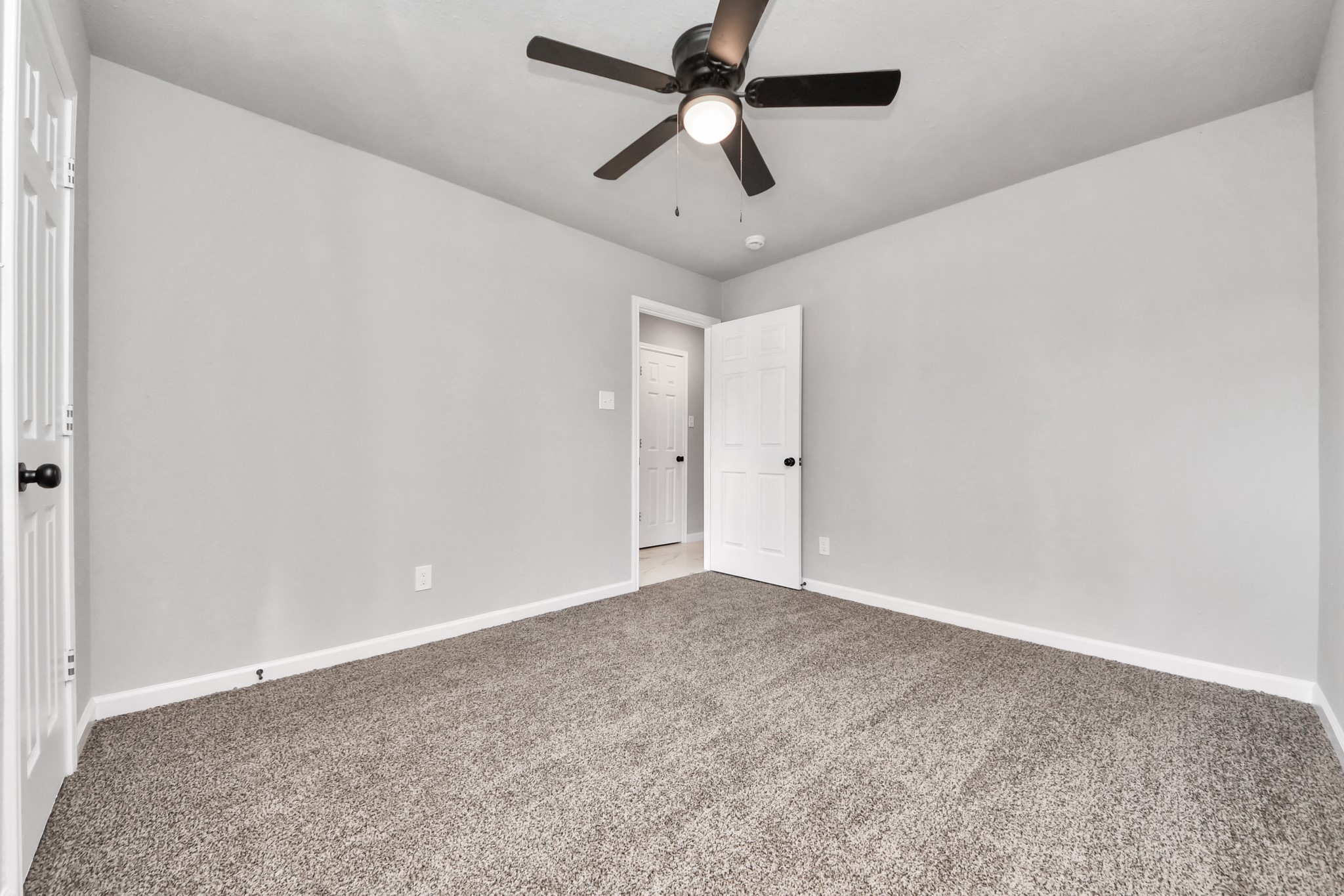 15123 Kaler Road Houston, TX 77060 - Photo 16 of 24 an empty room with a ceiling fan and carpet