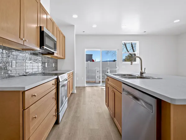 a kitchen with stainless steel appliances granite countertop a sink a microwave and cabinets