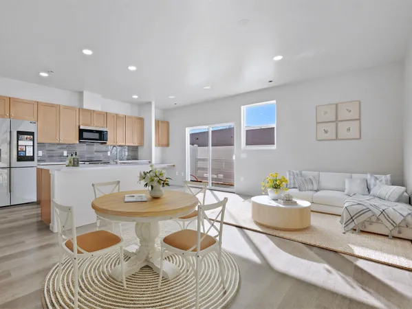 a kitchen with kitchen island granite countertop a stove a refrigerator a sink and white cabinets with wooden floor