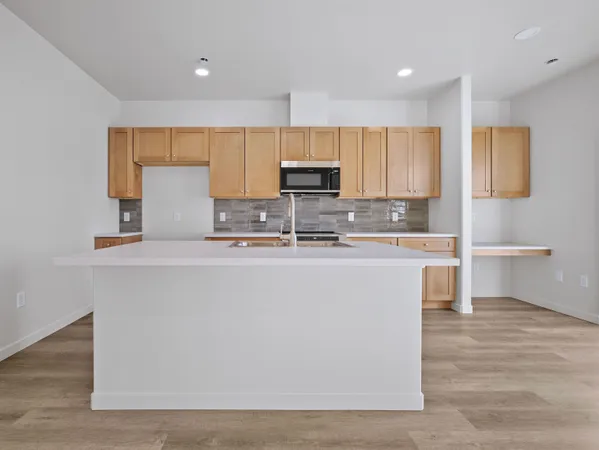 a view of kitchen with granite countertop cabinets and refrigerator