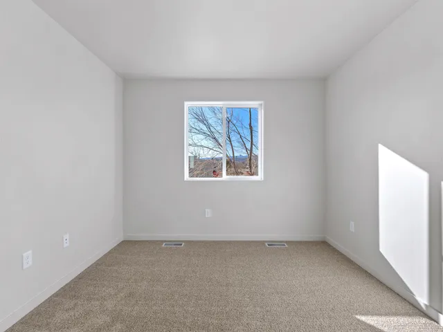 an empty room with a cabinet and mirrors