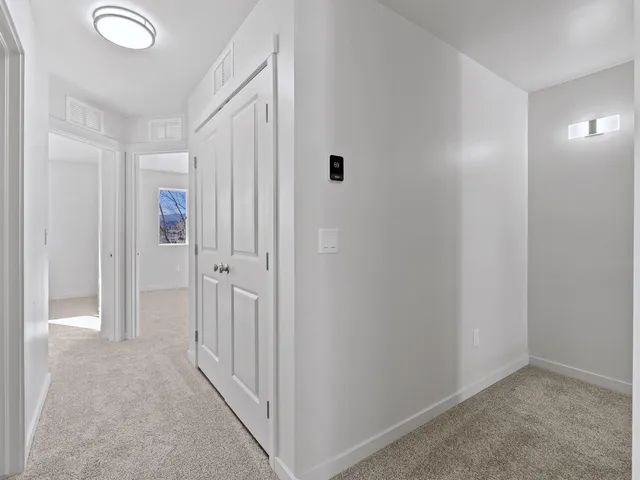 a living room with a bed and a dresser next to a window