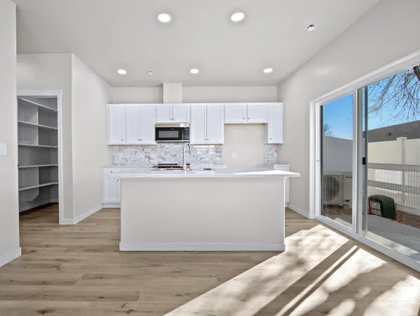 a kitchen with a sink cabinets and wooden floor