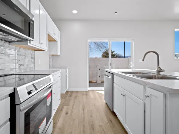 a kitchen with granite countertop white cabinets a sink and stainless steel appliances