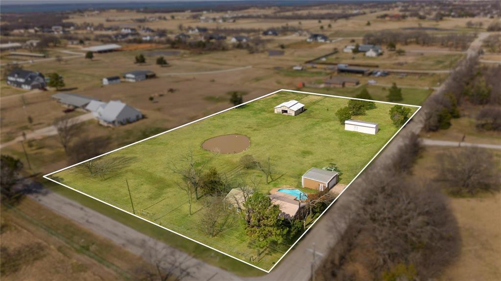 9213 Wilson Road Pilot Point, TX 76258 - Photo 2 of 36 Expansive parcel featuring a swimming pool, multiple outbuildings, a pond, and mature trees on a level grass lot