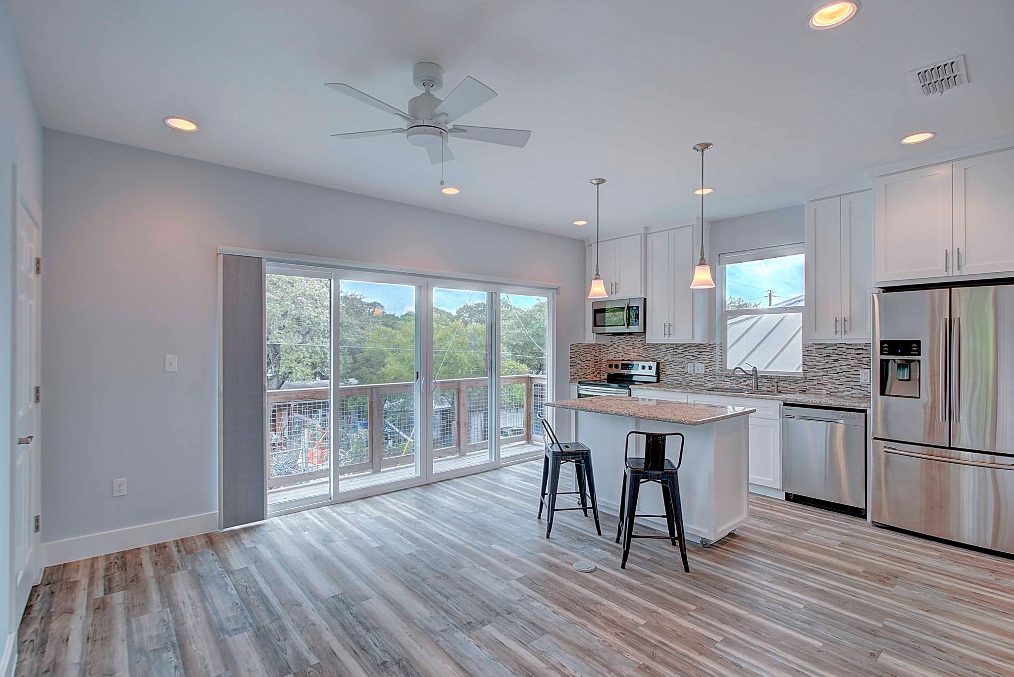 806 West Live Oak Street, Unit 2 Austin, TX 78704 - Photo 4 of 16 a kitchen with stainless steel appliances granite countertop a stove refrigerator a dining table and chairs with wooden floor