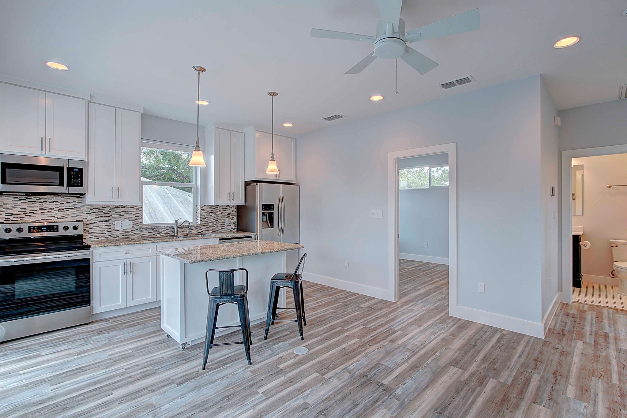 806 West Live Oak Street, Unit 2 Austin, TX 78704 - Photo 5 of 16 a kitchen with kitchen island granite countertop a sink a counter space stainless steel appliances and cabinets