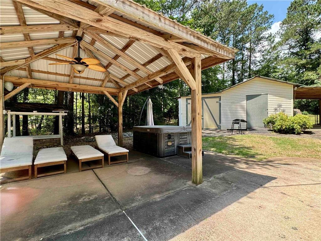 90 Howard Road Senoia, GA 30276 - Photo 11 of 73 a view of a patio with table and chairs under an umbrella with a small yard