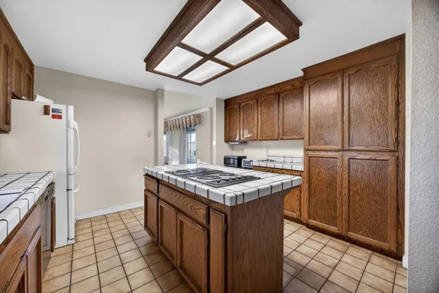a view of a hallway with wooden floor and a bathroom