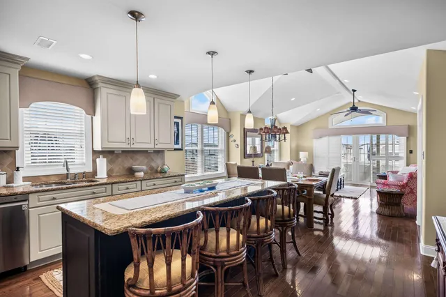 a kitchen with stainless steel appliances granite countertop a kitchen island a table and chairs
