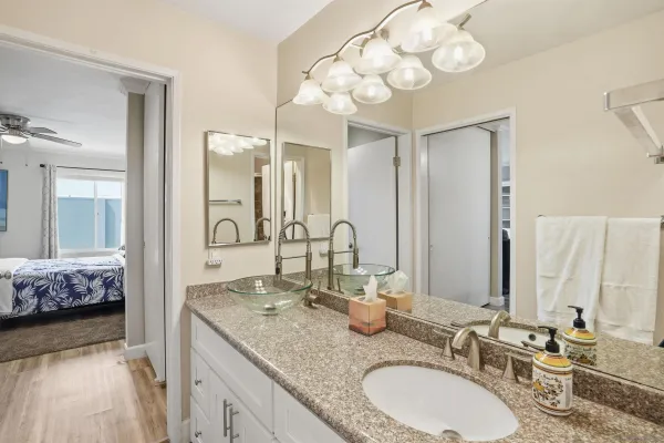 a bathroom with a granite countertop double vanity sink and a mirror
