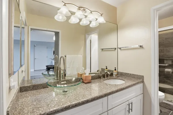 a bathroom with a granite countertop sink and a mirror