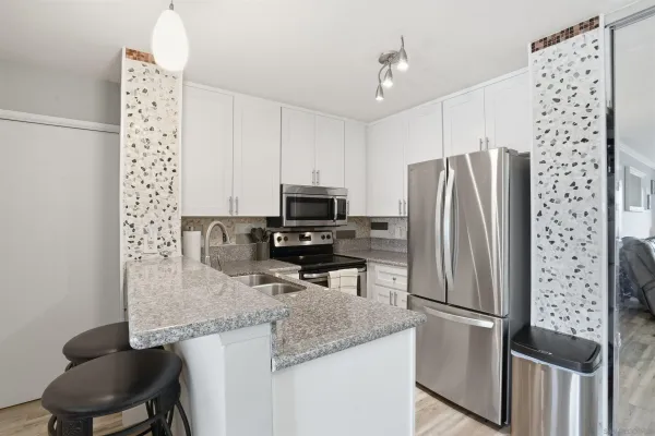 a kitchen with stainless steel appliances granite countertop a refrigerator a stove and a sink