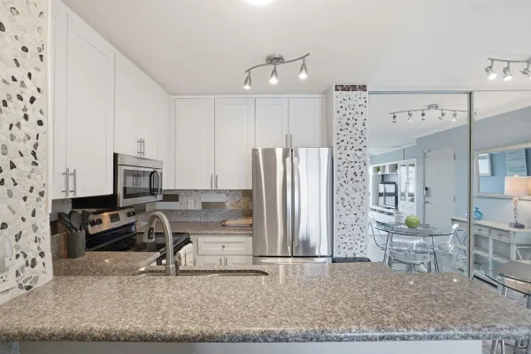 a kitchen with a refrigerator and a stove top oven