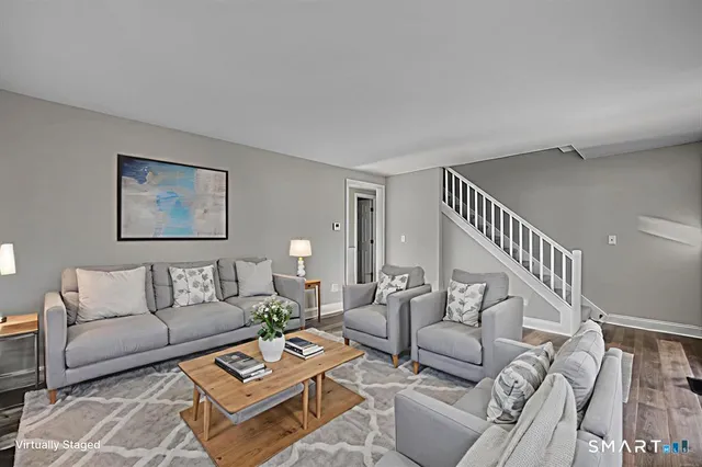 a living room with furniture and a table with wooden floor